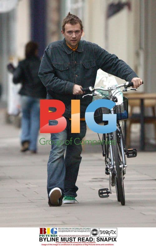 Damon Albarn pushing bike in London