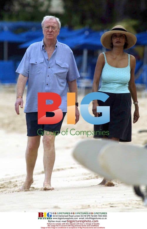 Michael Caine and his wife take a beach stroll