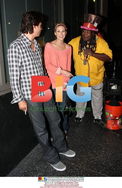 Stephanie Pratt walks with street performer