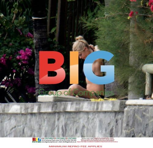 Chelsy Davy relaxes on beach with book and laptop