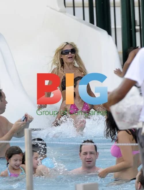 Shauna Sand relaxes poolside with daughters
