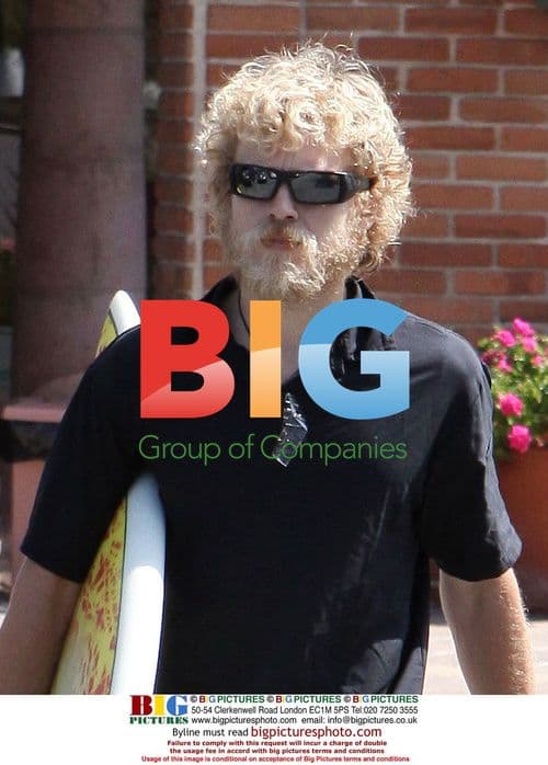 Spencer Pratt with long hair and surfboard