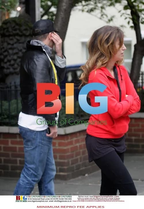 Robbie Williams attempts to hide face with girl