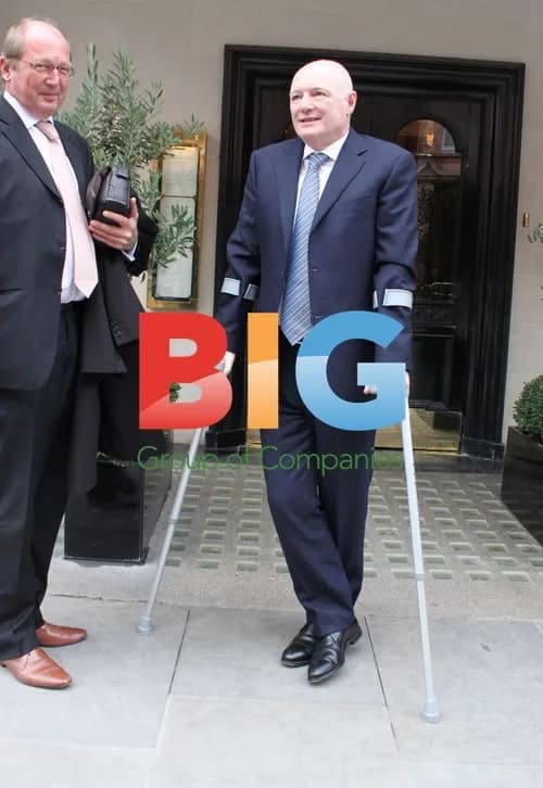 Peter Kenyon Smiles on Crutches