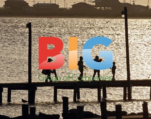Family walks on Grand Isle pier at sunset