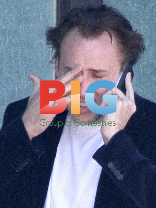 Nicolas Cage looks upset during phone call
