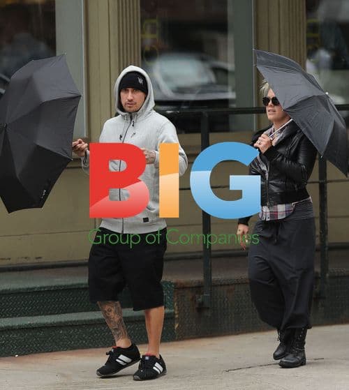 Pink and Carey Hart Walking with Umbrellas