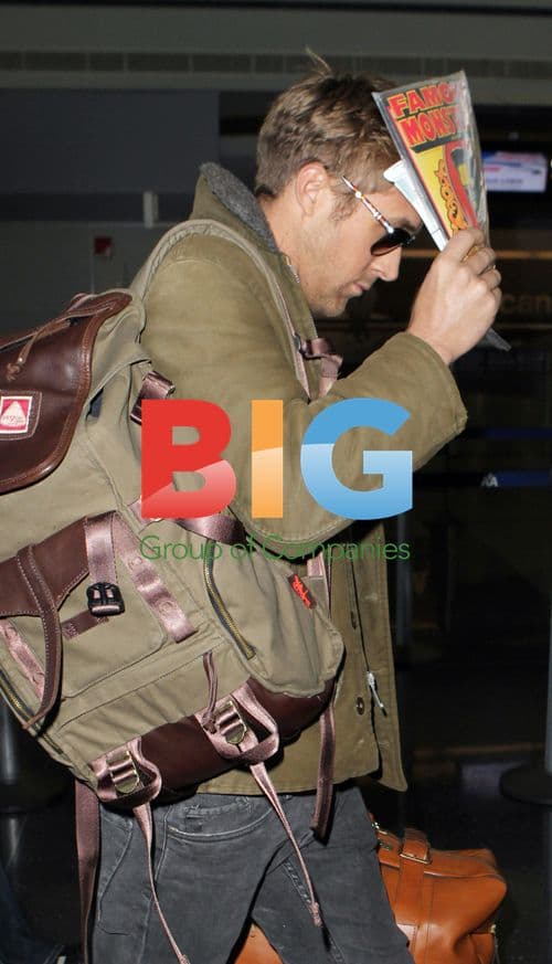 Ryan Gosling hides face at airport