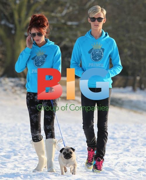 Amy Childs and Harry Derbidge play in snow with pug