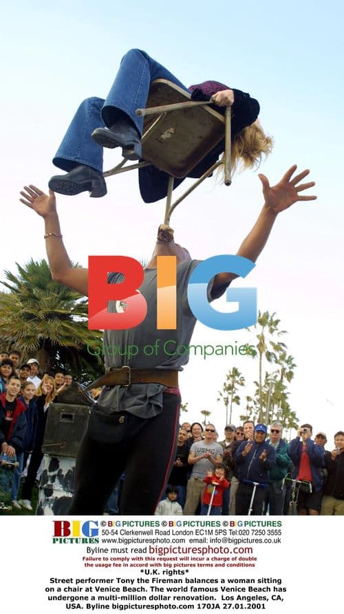 Street performer balances woman in Venice Beach