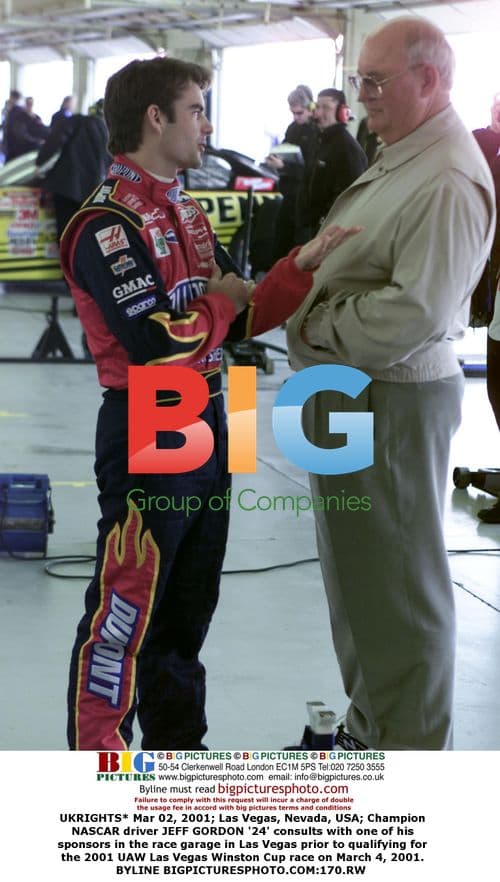Jeff Gordon consults with sponsor in NASCAR race garage