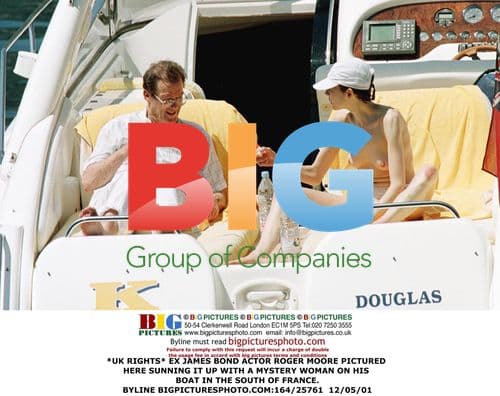 Roger Moore Relaxes on Boat with Mystery Woman