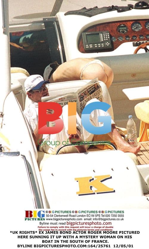 Roger Moore Relaxes on Boat with Mystery Woman