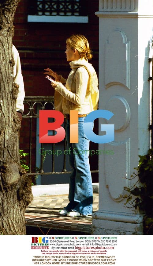 Kylie Intrigued by Phone Outside London Home