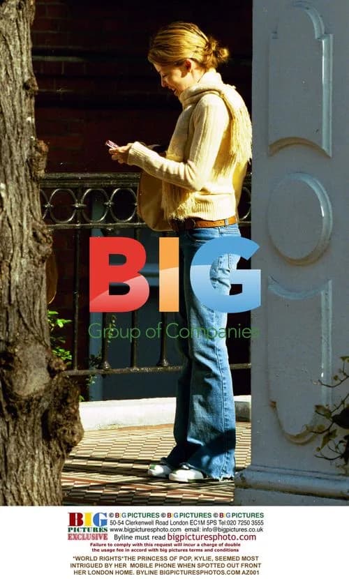 Kylie Intrigued by Phone Outside London Home