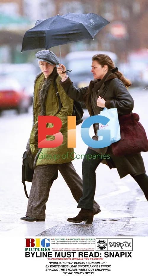 Annie Lennox braves storms while shopping in London