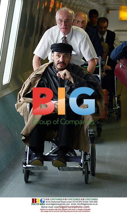 John Rhys-Davies in wheelchair at airport