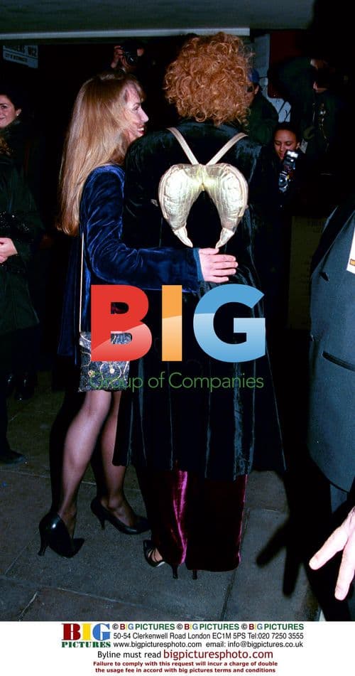 Alex Kingston in black coat and purple dress