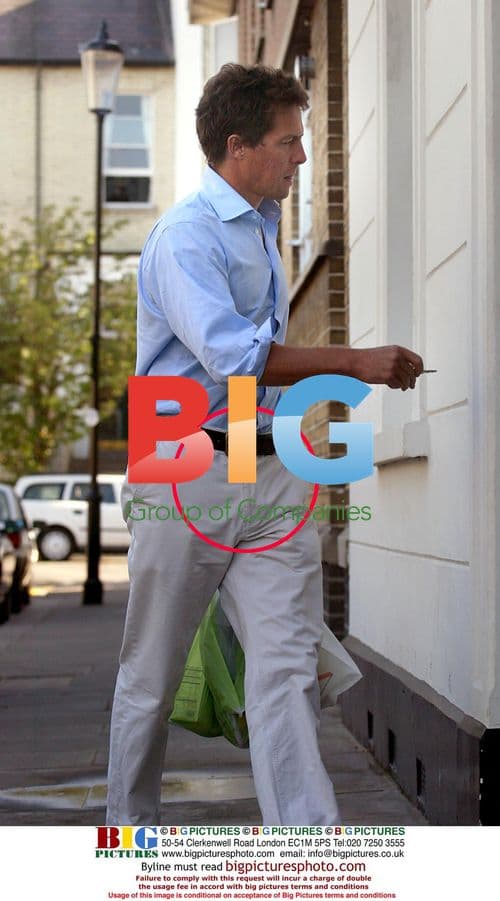 Hugh Grant returns home with shopping bags