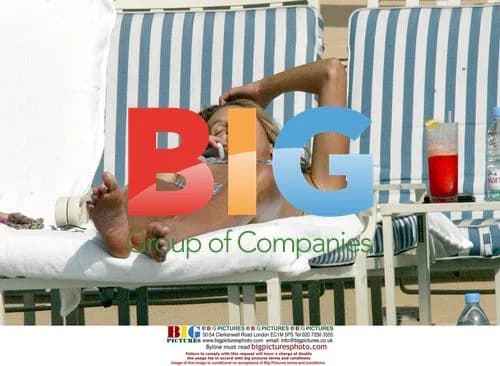 Elle Macpherson relaxing by hotel pool