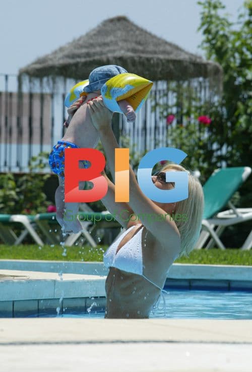 Singer Suzanne Shaw plays with child in pool