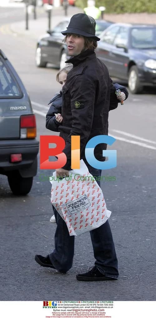Liam Gallagher carries son Gene across road