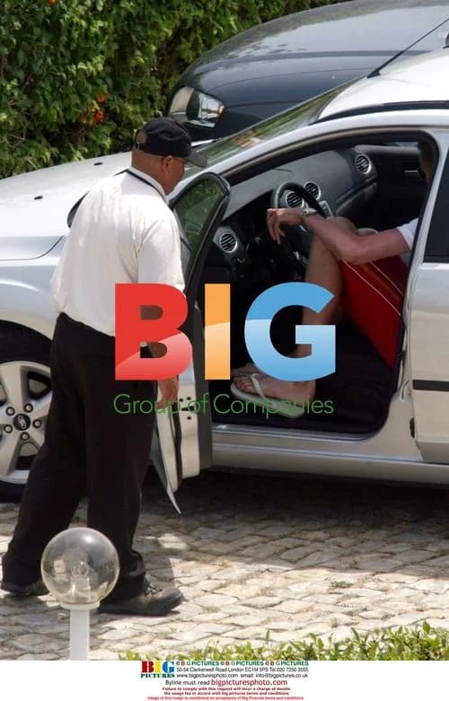 Footballer Peter Crouch crouching in car