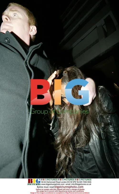 Naomi Campbell hides under bouncer's arm