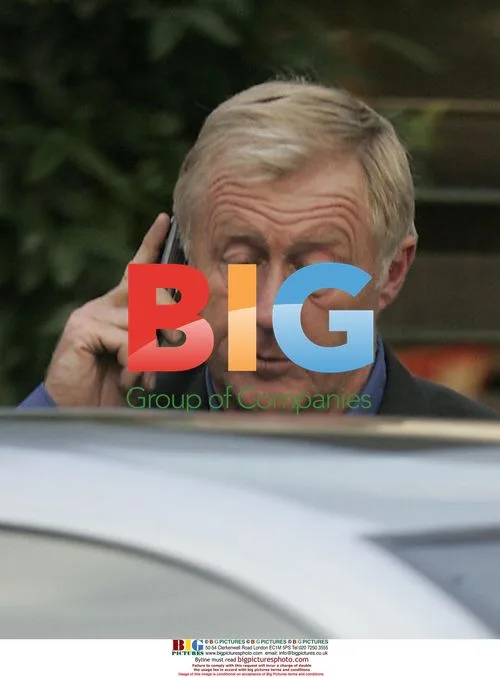 Chris Tarrant chatting on mobile outside cafe