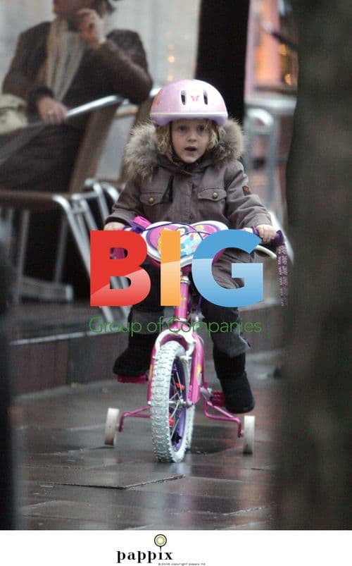 Misty Kyd rides bike in rainy London