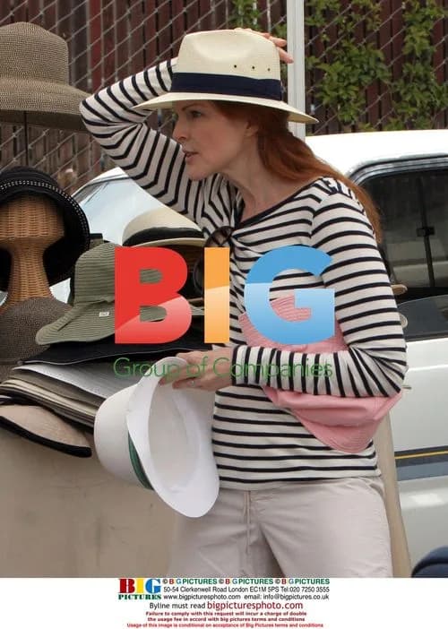 Marcia Cross tries on hats at Farmer's Market