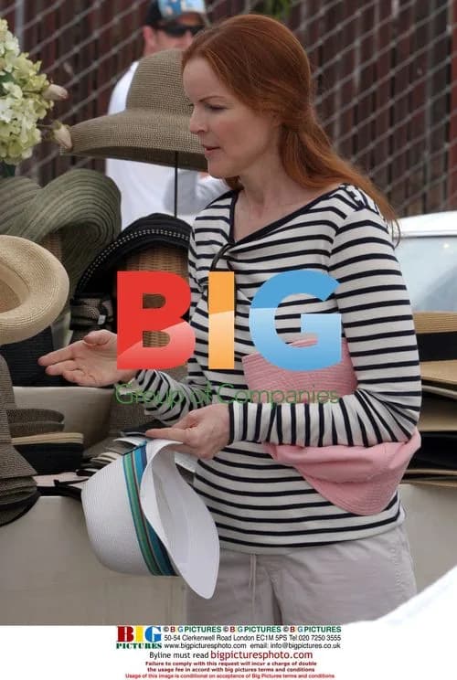 Marcia Cross tries on hats at Farmer's Market
