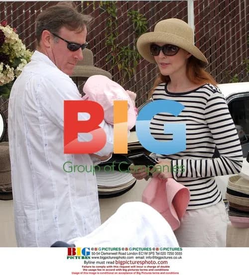 Marcia Cross tries on hats at Farmer's Market