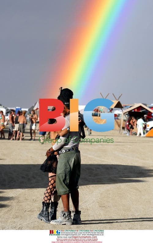 Couple kiss under rainbow at Burning Man