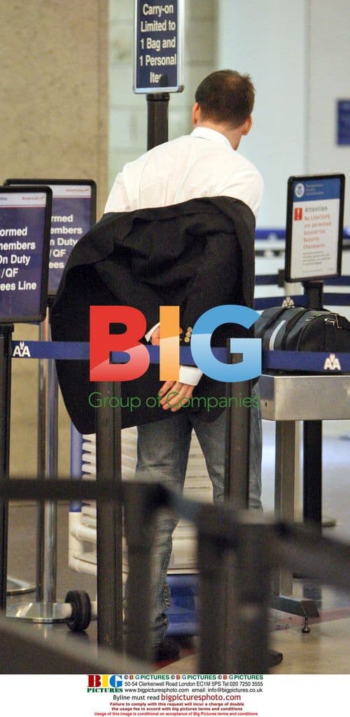 David Furnish Removes Shoes at LAX