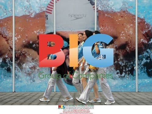 Volunteers pass Phelps photo at Beijing Olympics