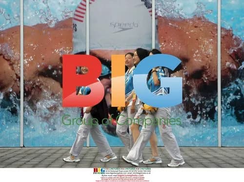 Volunteers pass Phelps photo at Beijing Olympics
