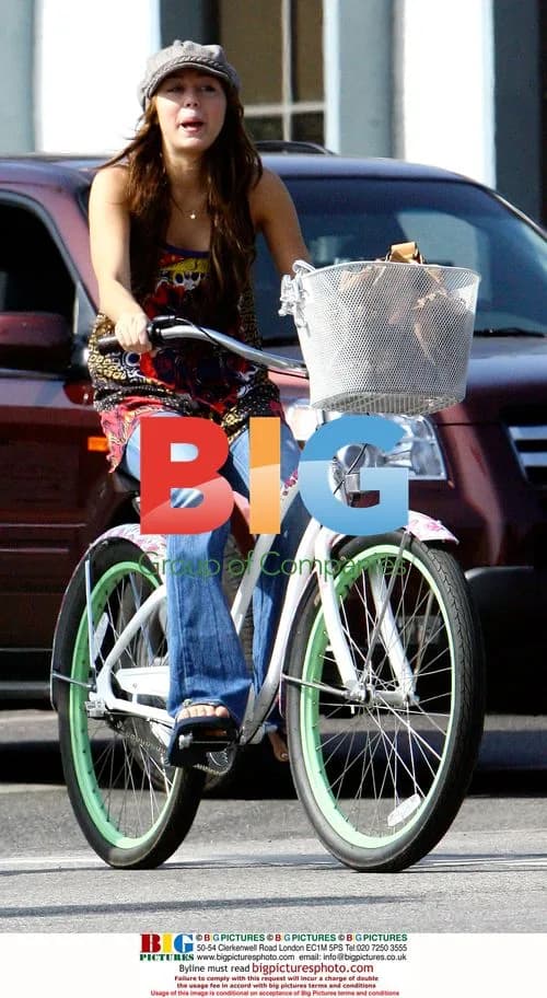 Miley Cyrus and Emily Osment riding bikes