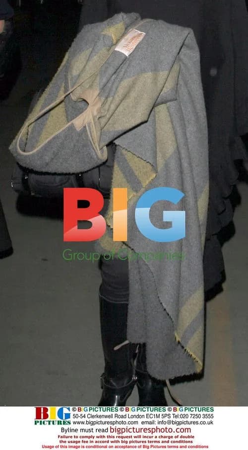 Gwen Stefani covers baby bump at LAX