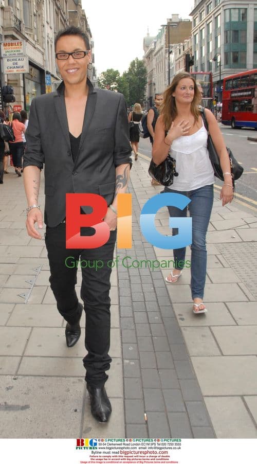 Gok Wan smiles while strolling with friend