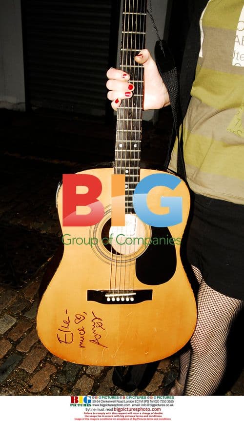 Amy Winehouse signs guitar for fans