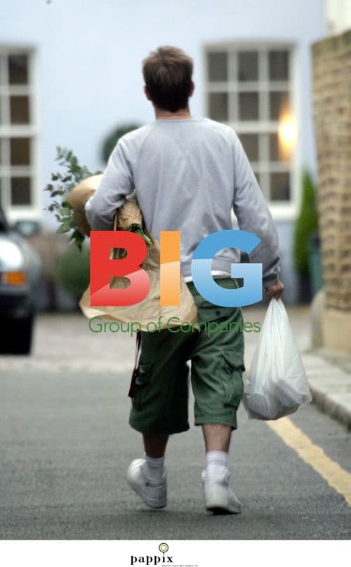 Jason Donovan strides through London with bananas and flowers