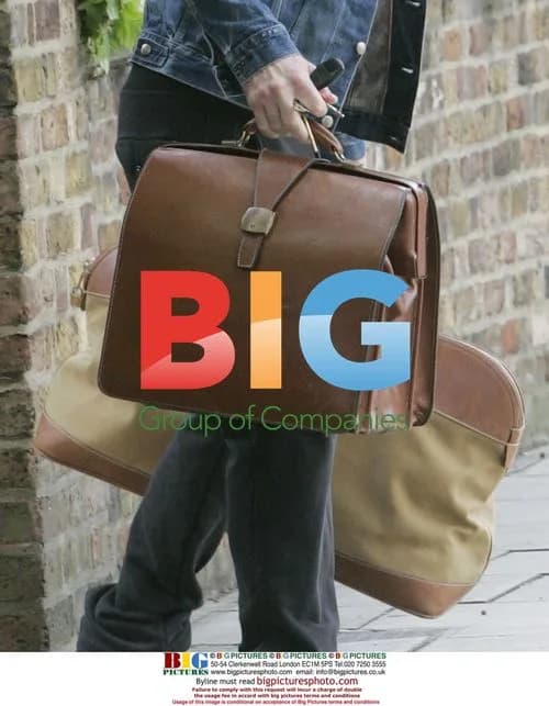 Jude Law Waits for Lift with Luggage in London