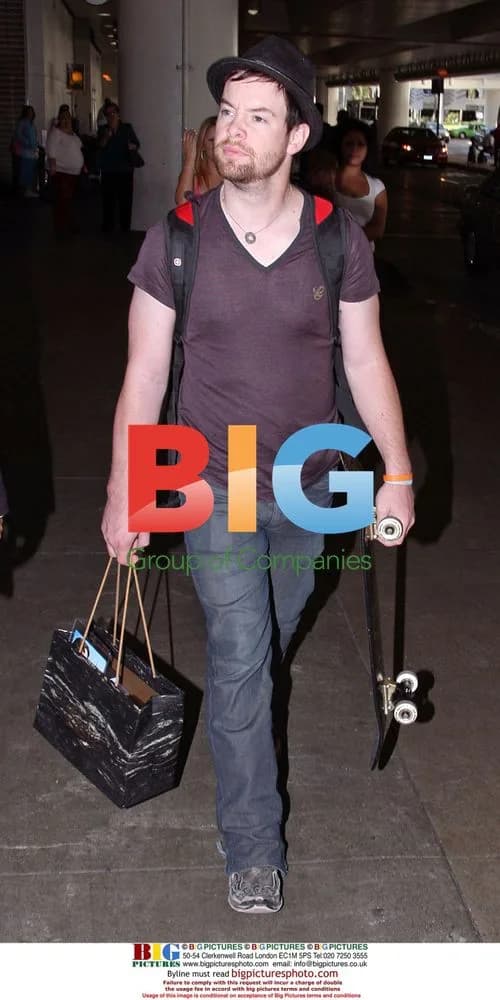 David Cook arrives at LAX with skateboard