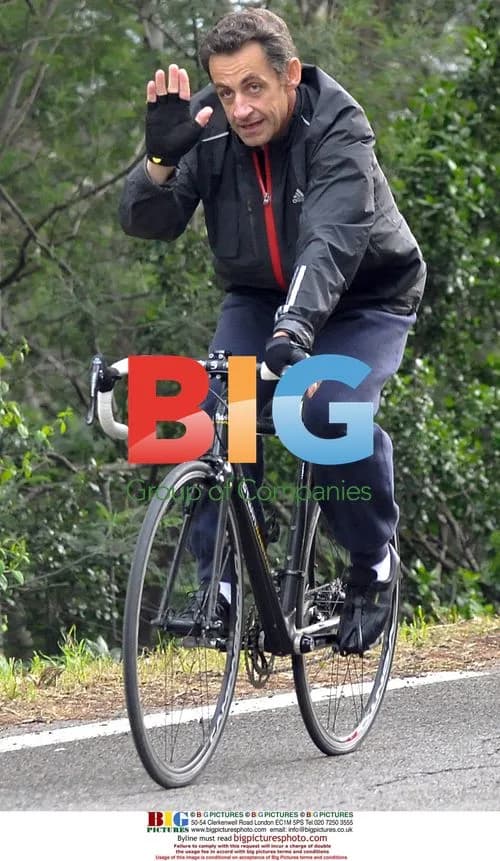Nicolas Sarkozy cycles in the rain
