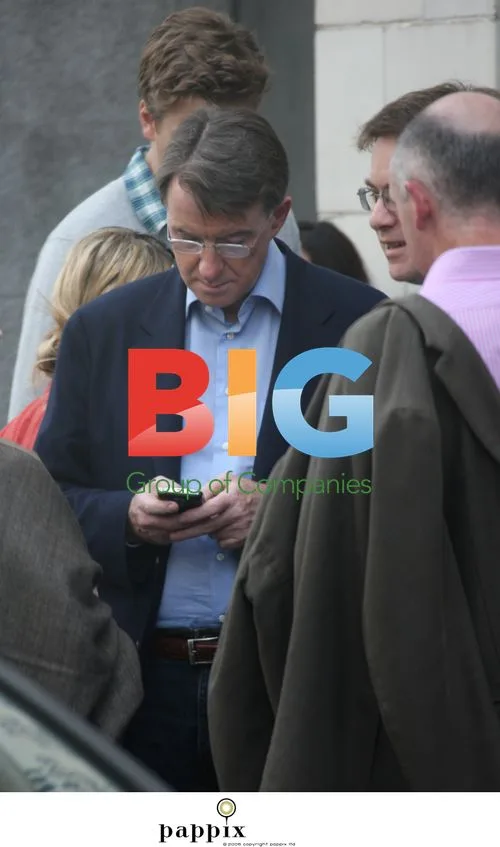 Peter Mandelson checks mobile before cinema