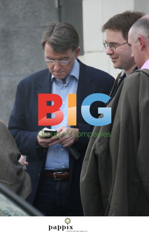 Peter Mandelson checks phone with aide
