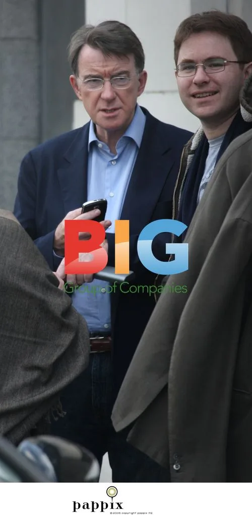 Peter Mandelson checks phone with aide