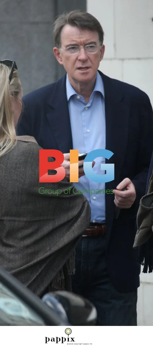 Peter Mandelson checks his phone