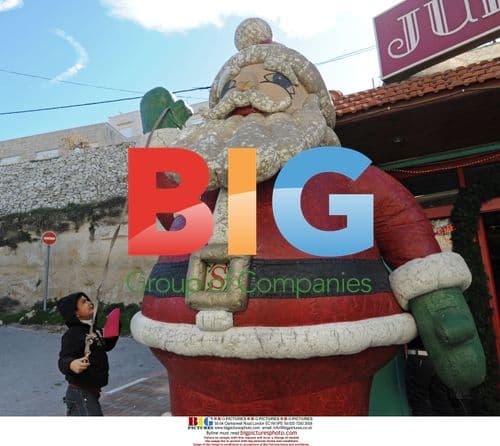 Palestinian boy plays with Santa in Bethlehem